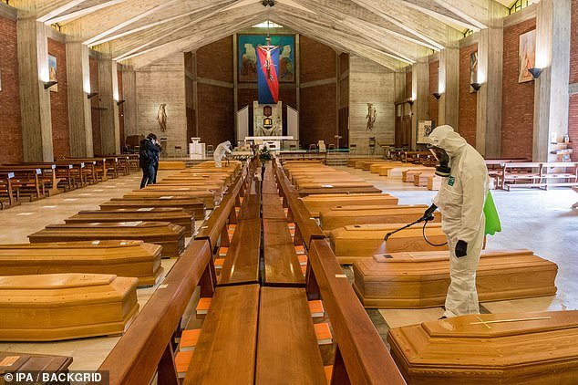 Italy's death toll increased by 969 yesterday, bringing the total to 9,134, the largest 24-hour increase in the country to date. Pictured: Army medical staff disinfect coffins being kept in a church near Bergamo, Italy