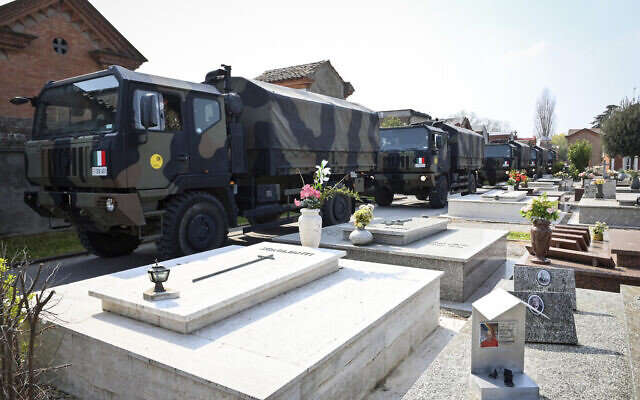 A convoy of Italian Army trucks arrives from Bergamo carrying bodies of coronavirus victims to the cemetery of Ferrara, Italy, where they will be cremated, Saturday, March 21, 2020. (Massimo Paolone/LaPresse via AP)